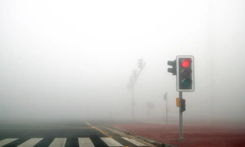 low visibility due to dense fog causing a dangerous intersection