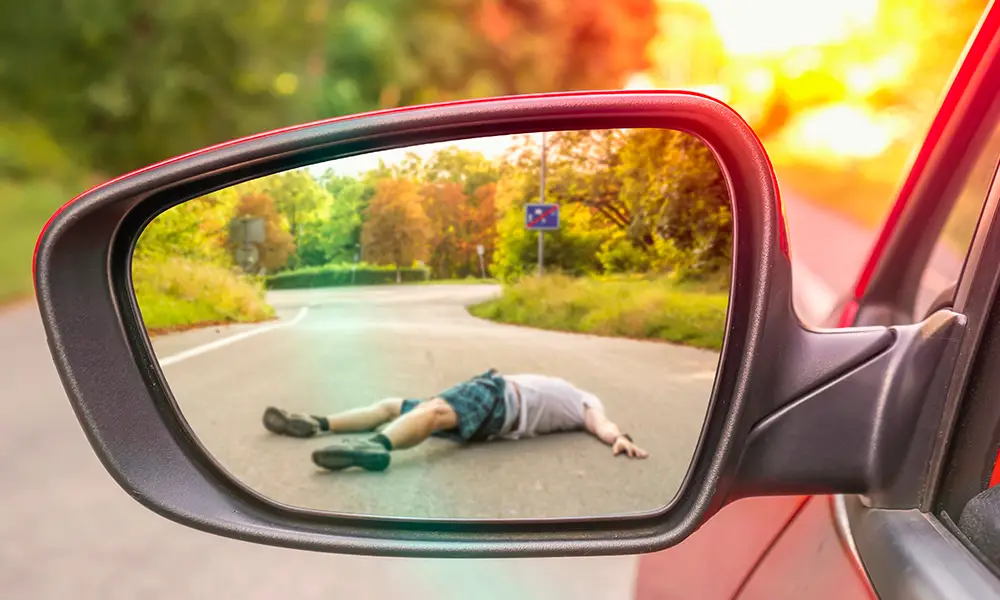 rear-view mirror showing a person involved in a hit by car accident - Hit by car accident lawyer collinsville il