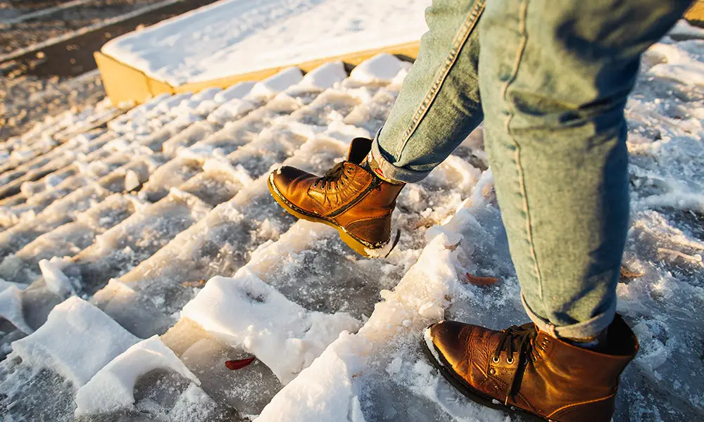 person walking on an icy stairway without handles to hold for stability - slip and fall accident