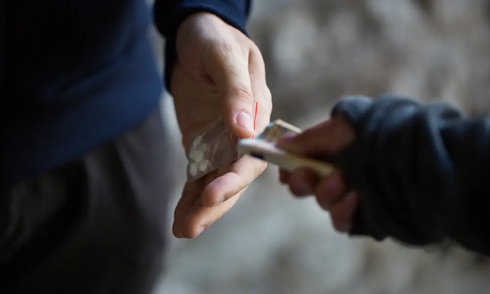 close up of addict buying dose from drug dealer - drug crime defense lawyer collinsville il